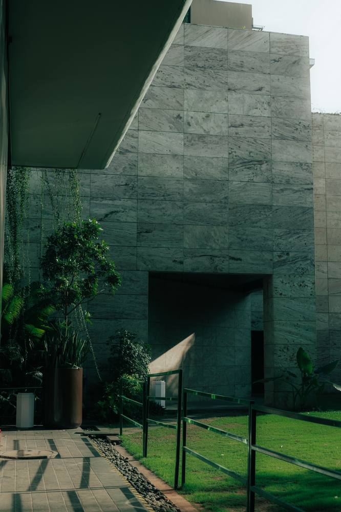 Modern building exterior with a covered walkway and greenery