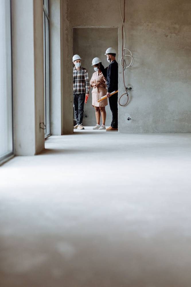 Construction team reviewing blueprints on site with hard hats