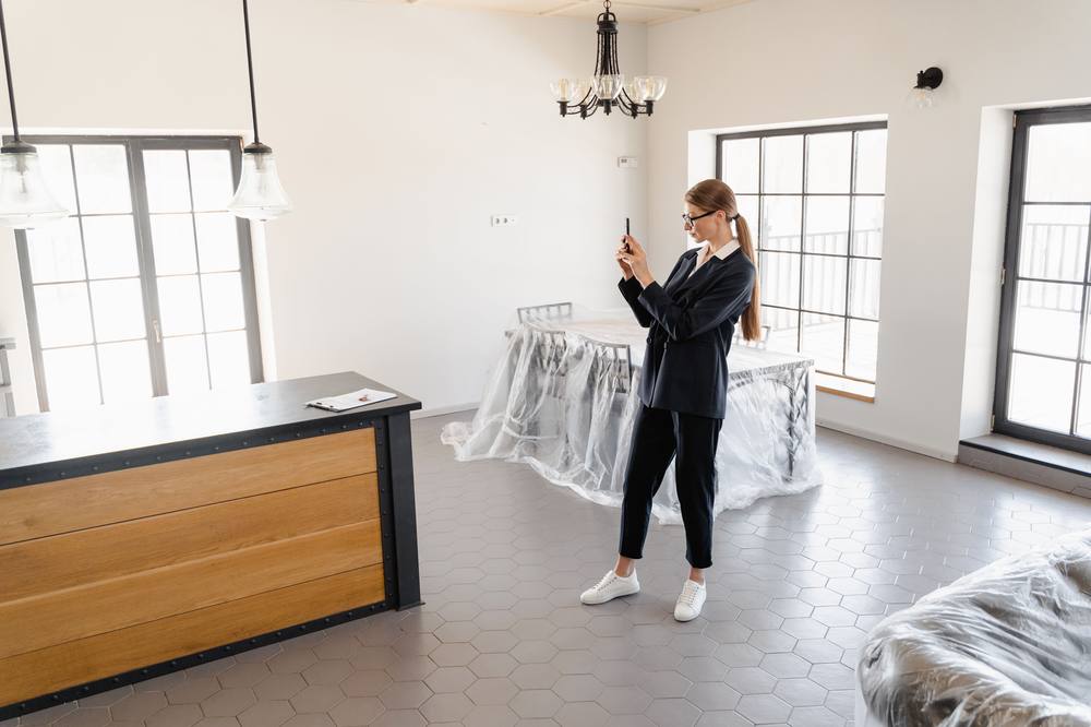 Woman photographing a renovated room during final walkthrough