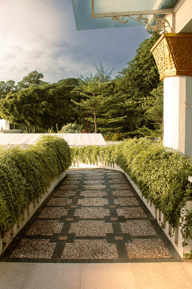 Garden walkway leading to a grand entrance