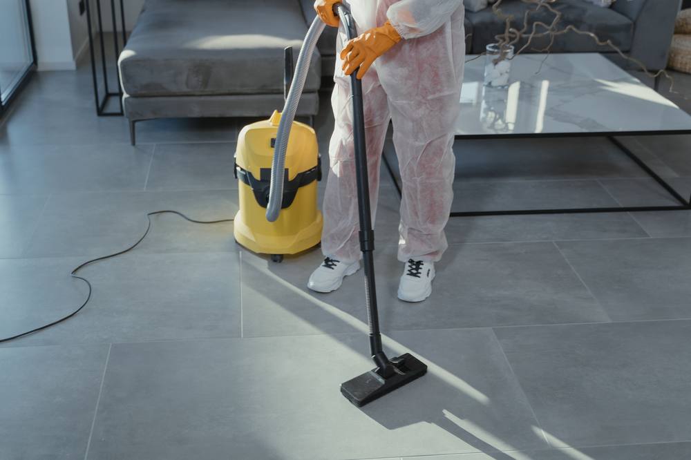 Vacuuming a tiled floor with a wet/dry vacuum hose
